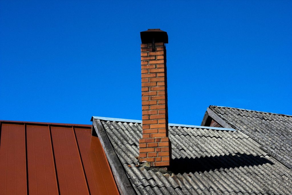 Backsteinkamin auf einem Dach unter blauem Himmel
