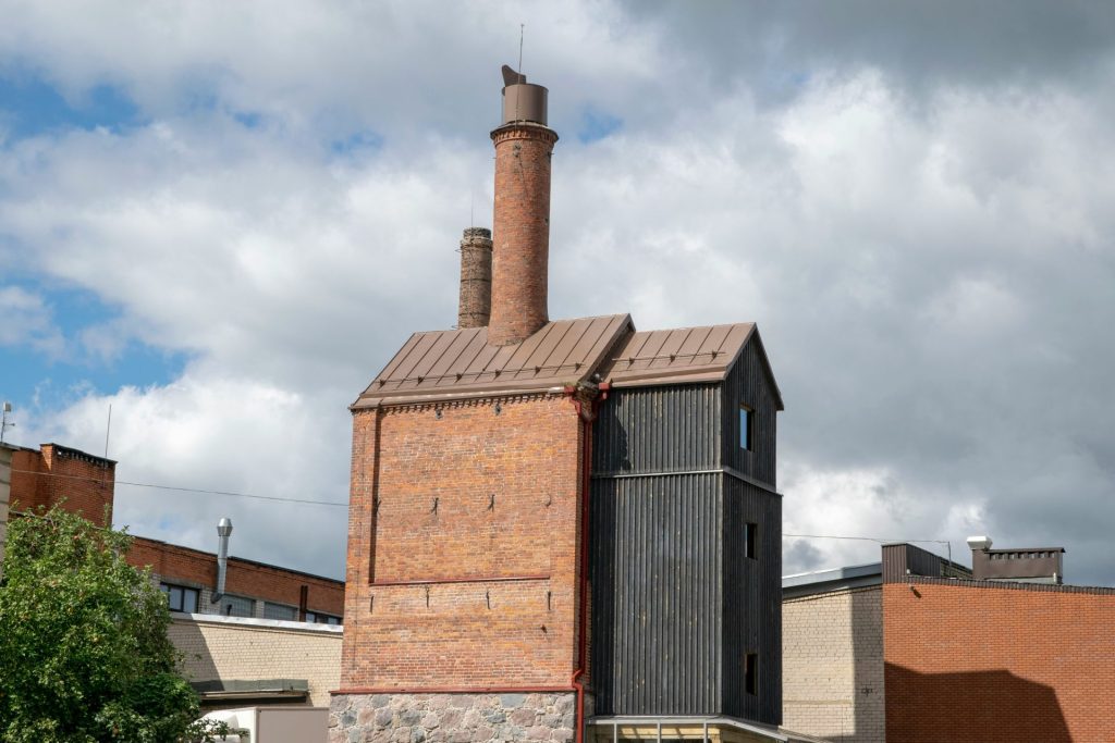 ein hohes Backsteingebäude mit einem Schornstein auf dem Dach