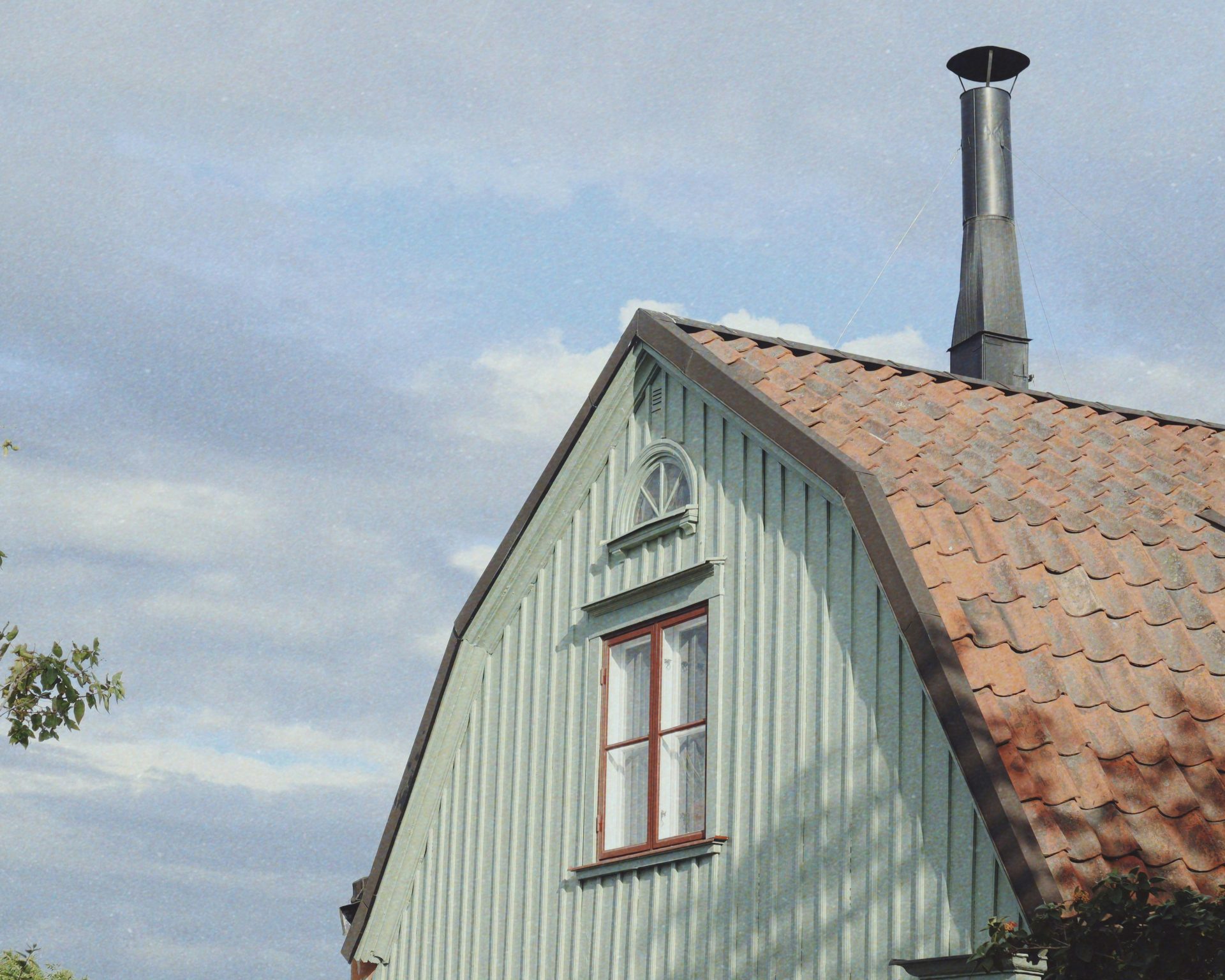 a white house with a red roof and a chimney